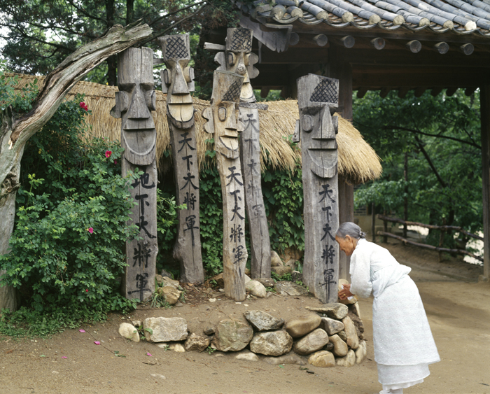 Elderly woman praying to guardian jangseung